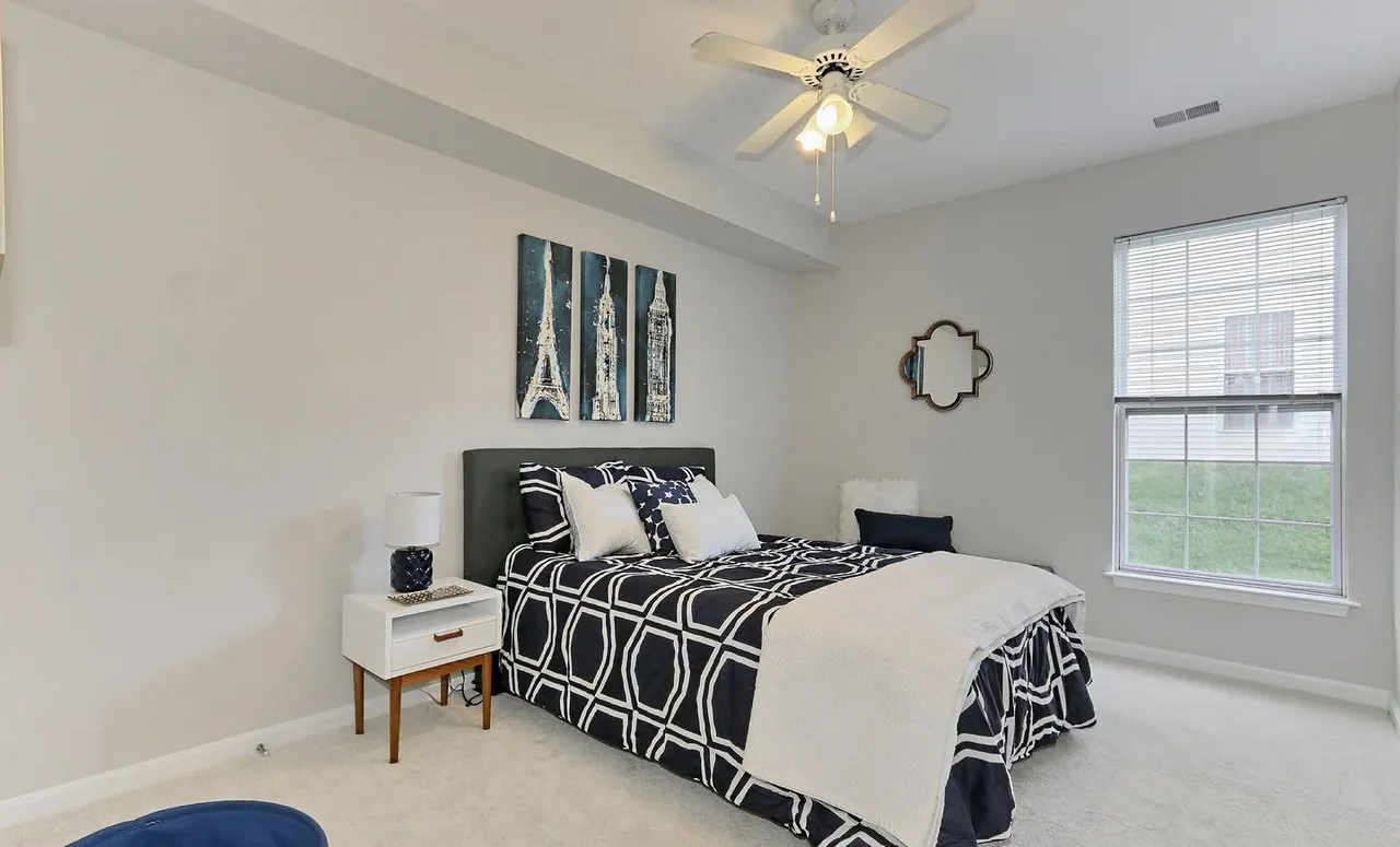 Staged guest bedroom with navy and white bedding.