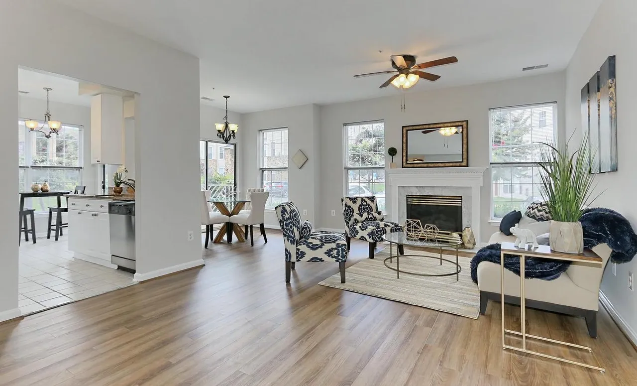 Open living and dining room with new hardwood-style flooring, staged with modern furniture.