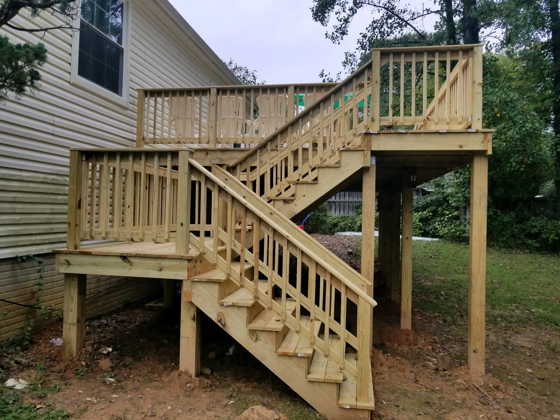 New pressure-treated deck with a full staircase, framed and railed.